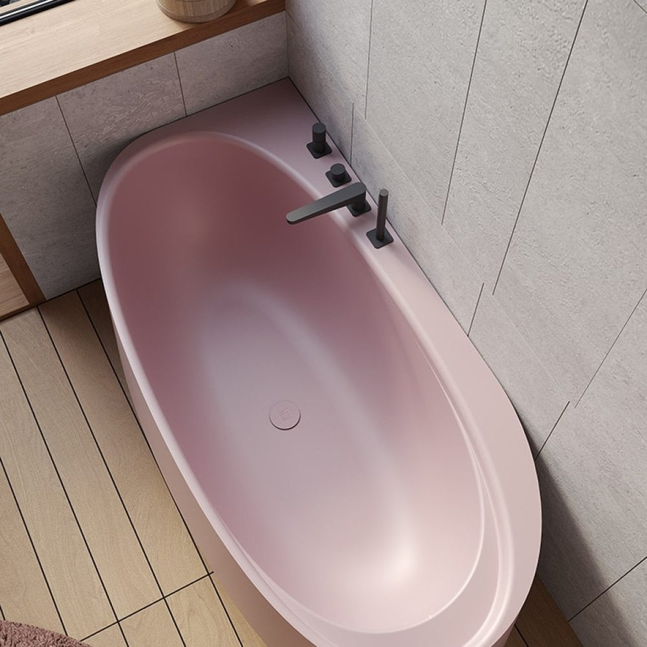 Vasca angolare IKI rosa opaco con rubinetteria nera, vista dall'alto su pavimento legno