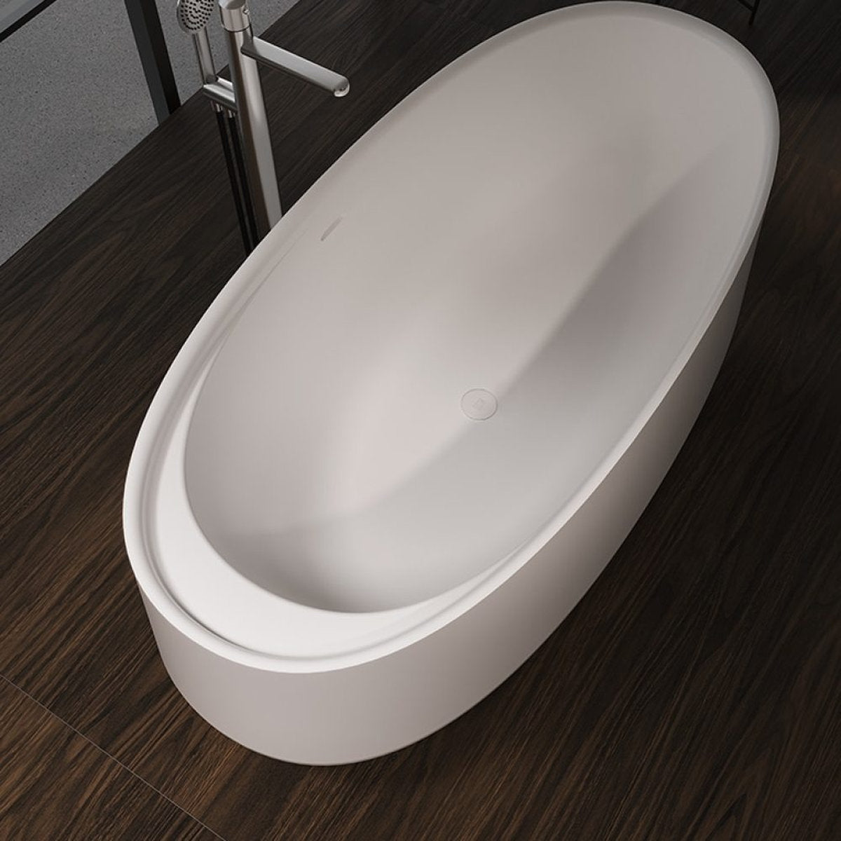 Vasca ovale IKI Forma Aquae bianco opaco vista dall'alto su pavimento scuro con rubinetteria a terra