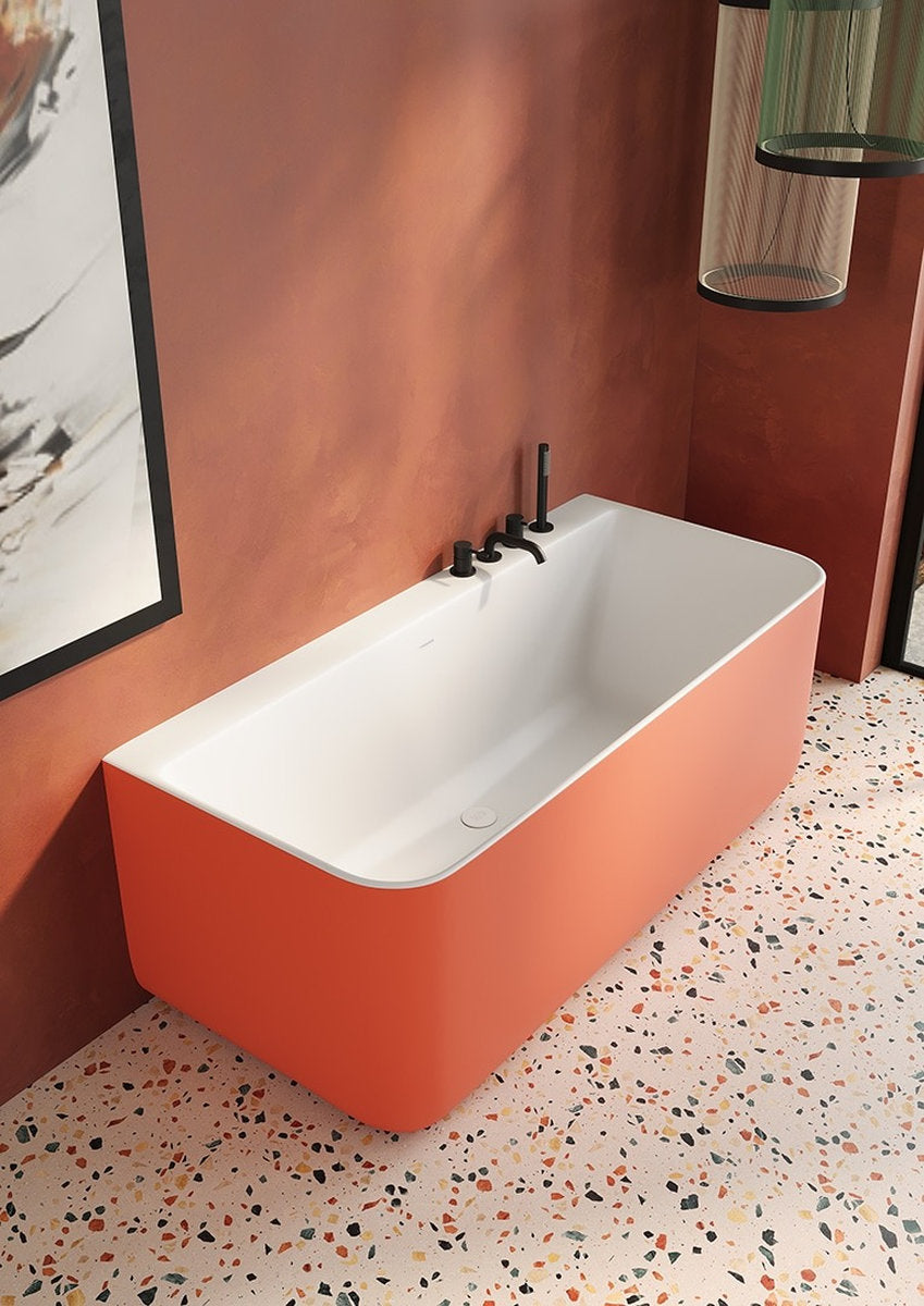 Dettaglio vasca bagno Oasi Small Wall arancio con bordi arrotondati su pavimento graniglia